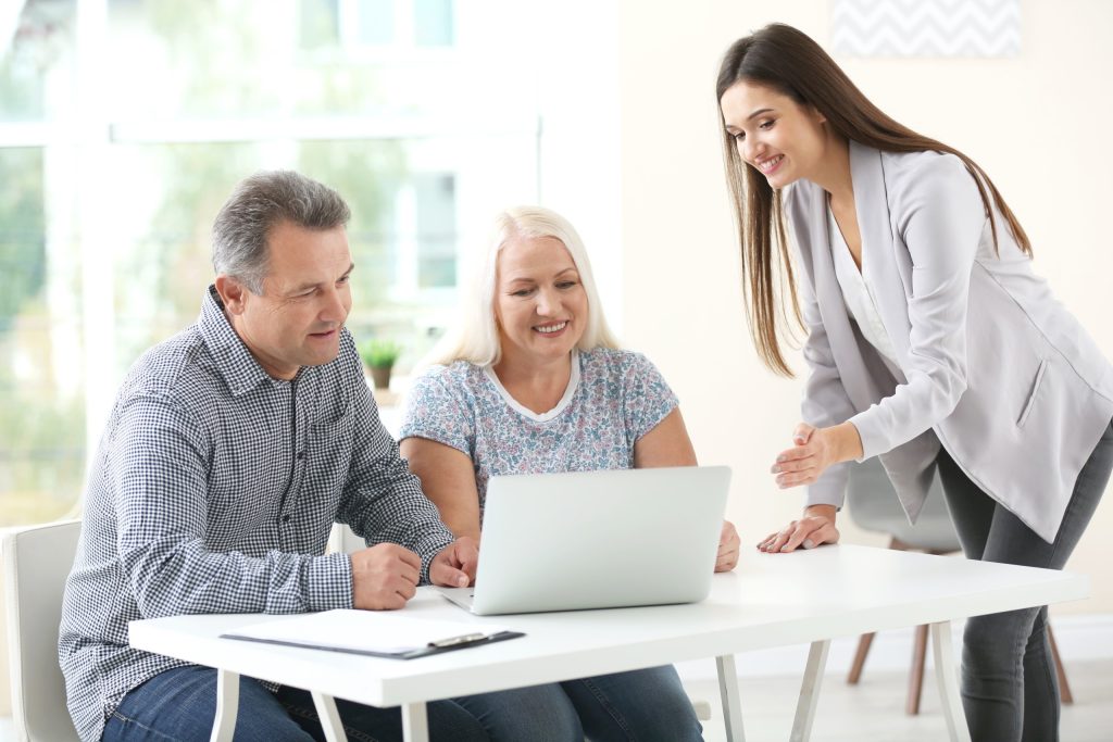 Female insurance agent consulting senior couple in office