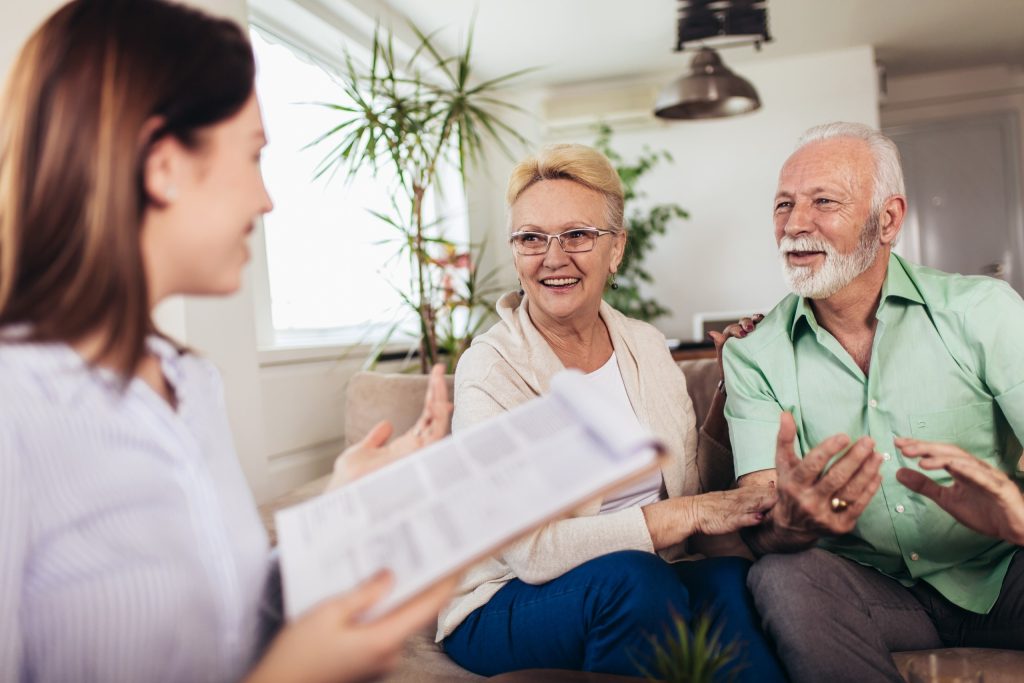 Happy elderly couple consulting with insurance agent