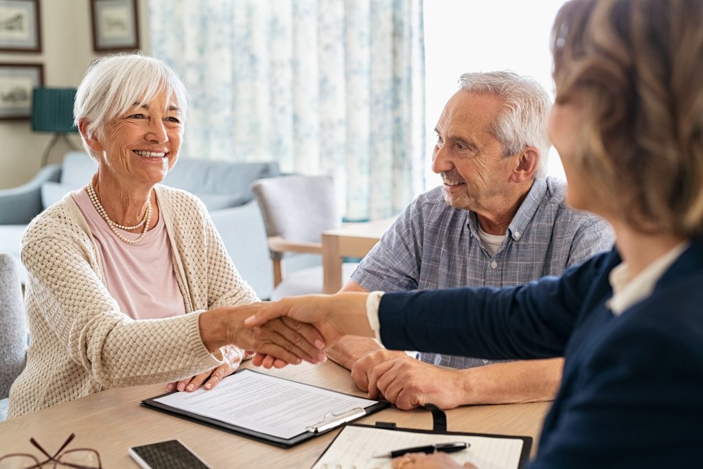 Financial advisor shaking hands with senior woman after a deal