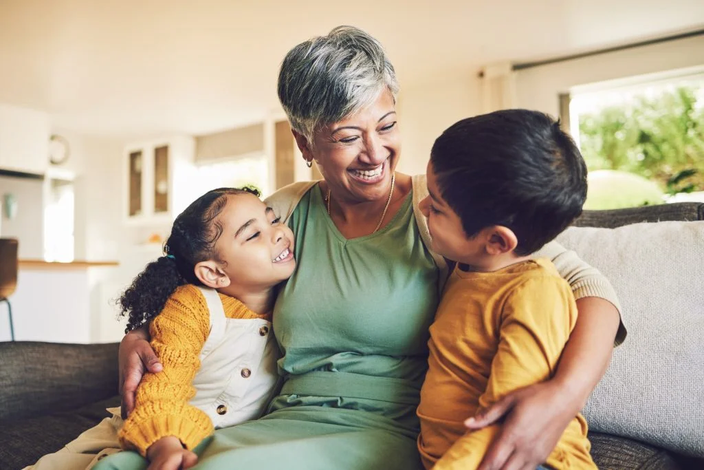 Smile, affection or funny senior grandparent with children siblings on house couch laughing